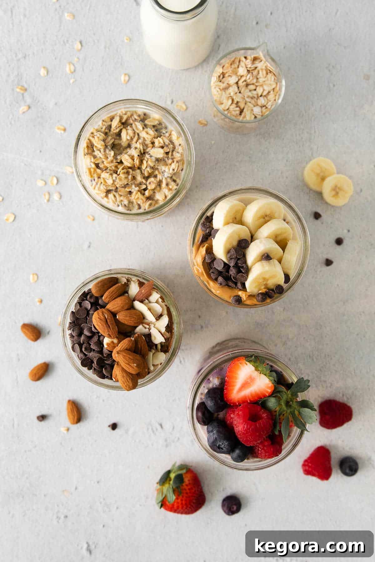 An overhead view of several jars filled with different types of gluten-free overnight oats, topped with various ingredients like berries, nuts, and chocolate chips.