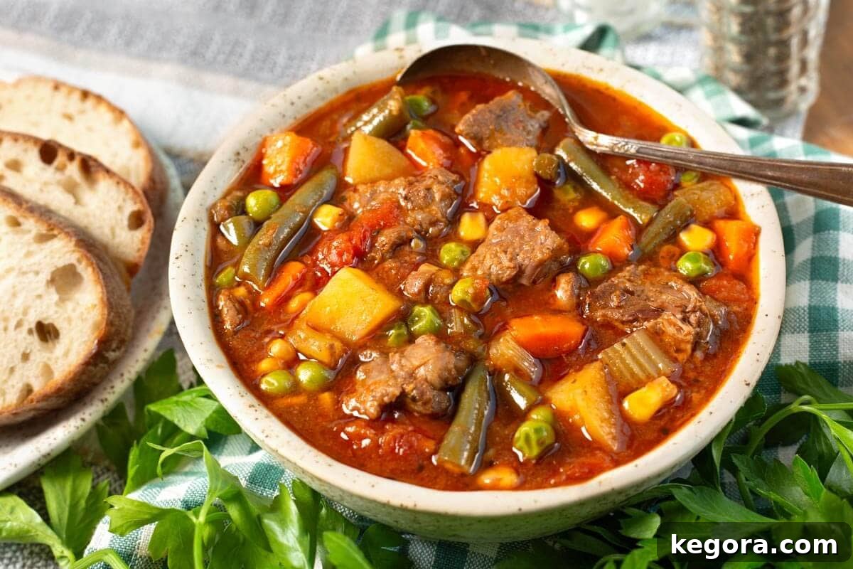 Wholesome Slow Cooker Beef and Garden Vegetable Soup 3 Close-up of Crockpot Vegetable Beef Soup in a white bowl, garnished with fresh parsley