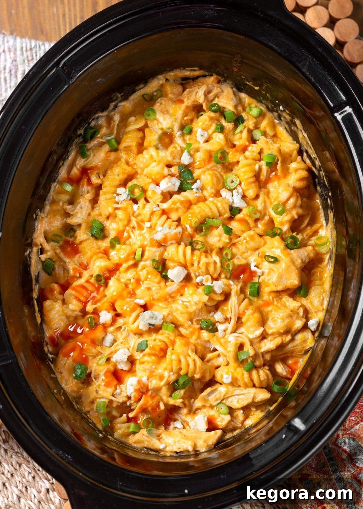 Creamy and cheesy Crockpot Buffalo Chicken Mac and Cheese with shredded chicken and a drizzle of sauce