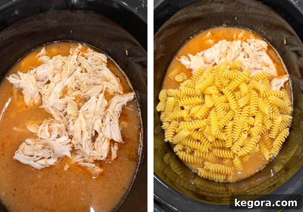 Shredded chicken returned to the crockpot, with uncooked rotini pasta added