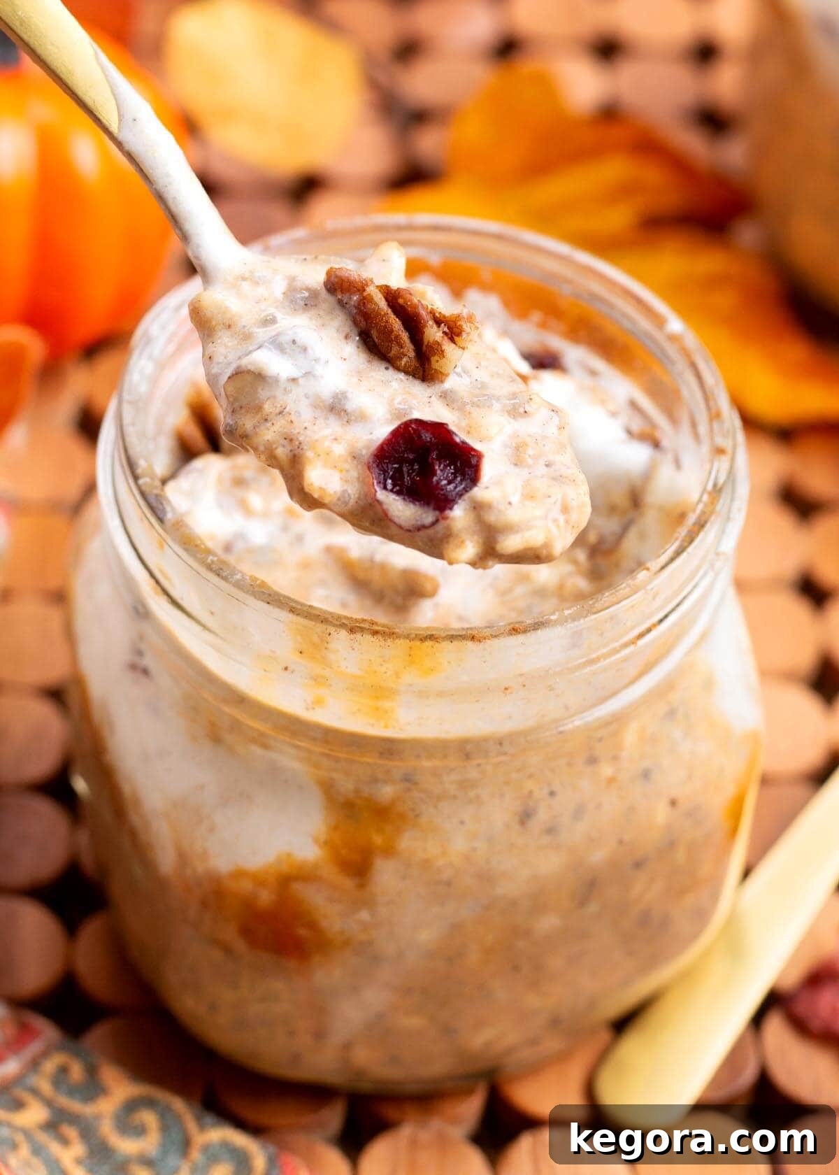 Pumpkin Spice Overnight Delight 9 Close-up of a jar of Pumpkin Overnight Oats with a spoon and fall leaves
