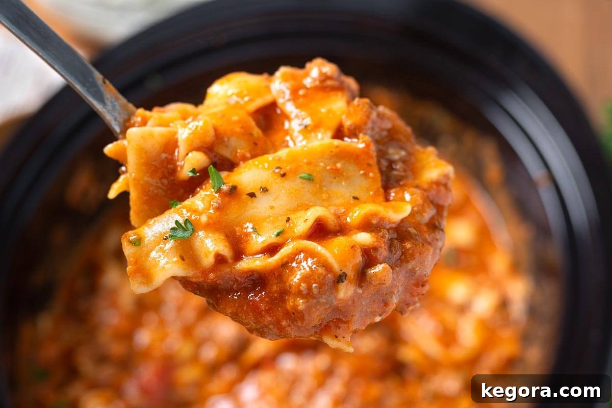 Effortless Slow Cooker Lasagna Soup 10 A close-up shot of a single bowl of Crockpot Lasagna Soup, garnished with fresh parsley, highlighting the rich broth, tender noodles, and creamy cheese topping.