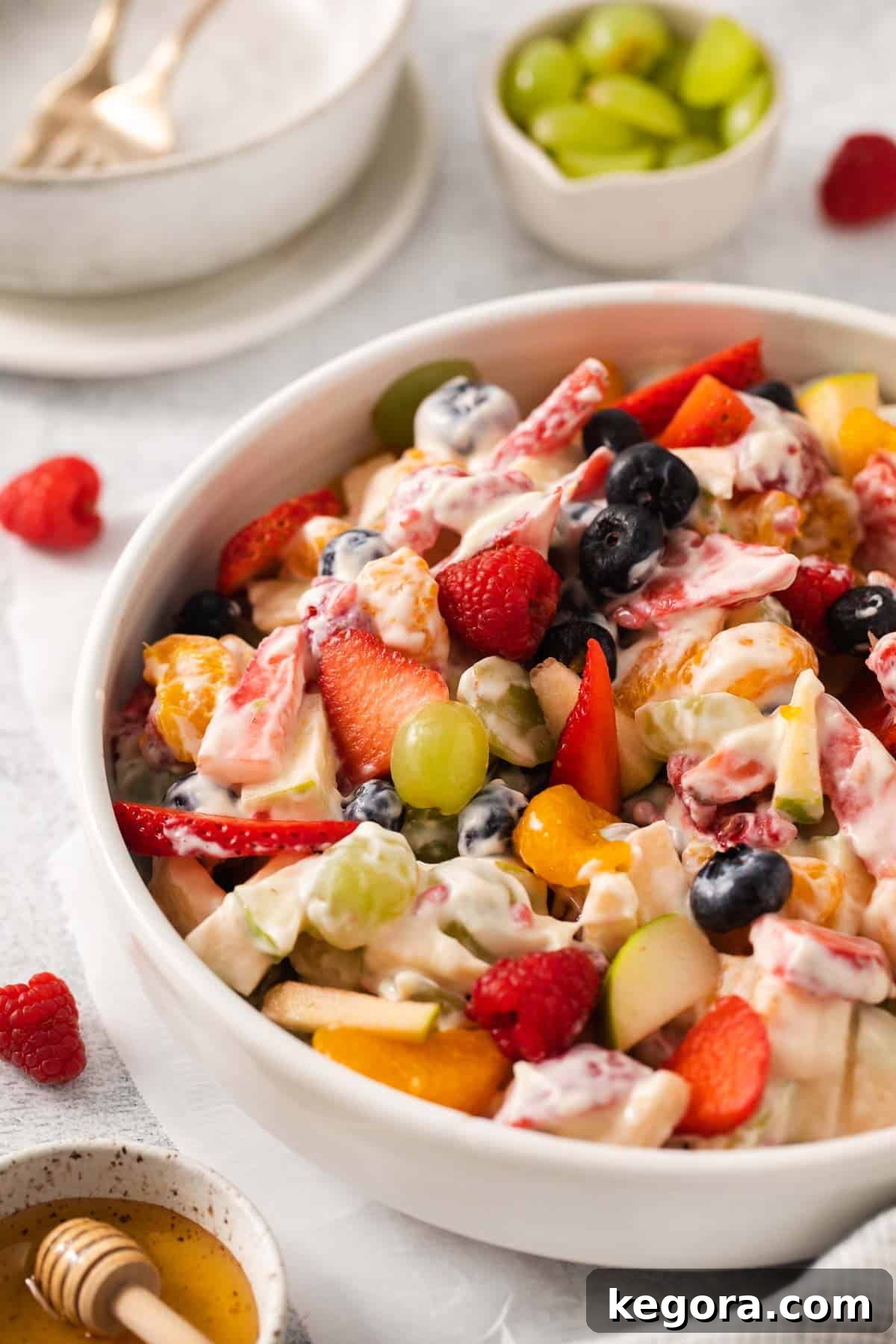 Festive Easter Fruit Delight 2 A closeup view of colorful Easter fruit salad in a bowl, topped with a creamy white dressing.