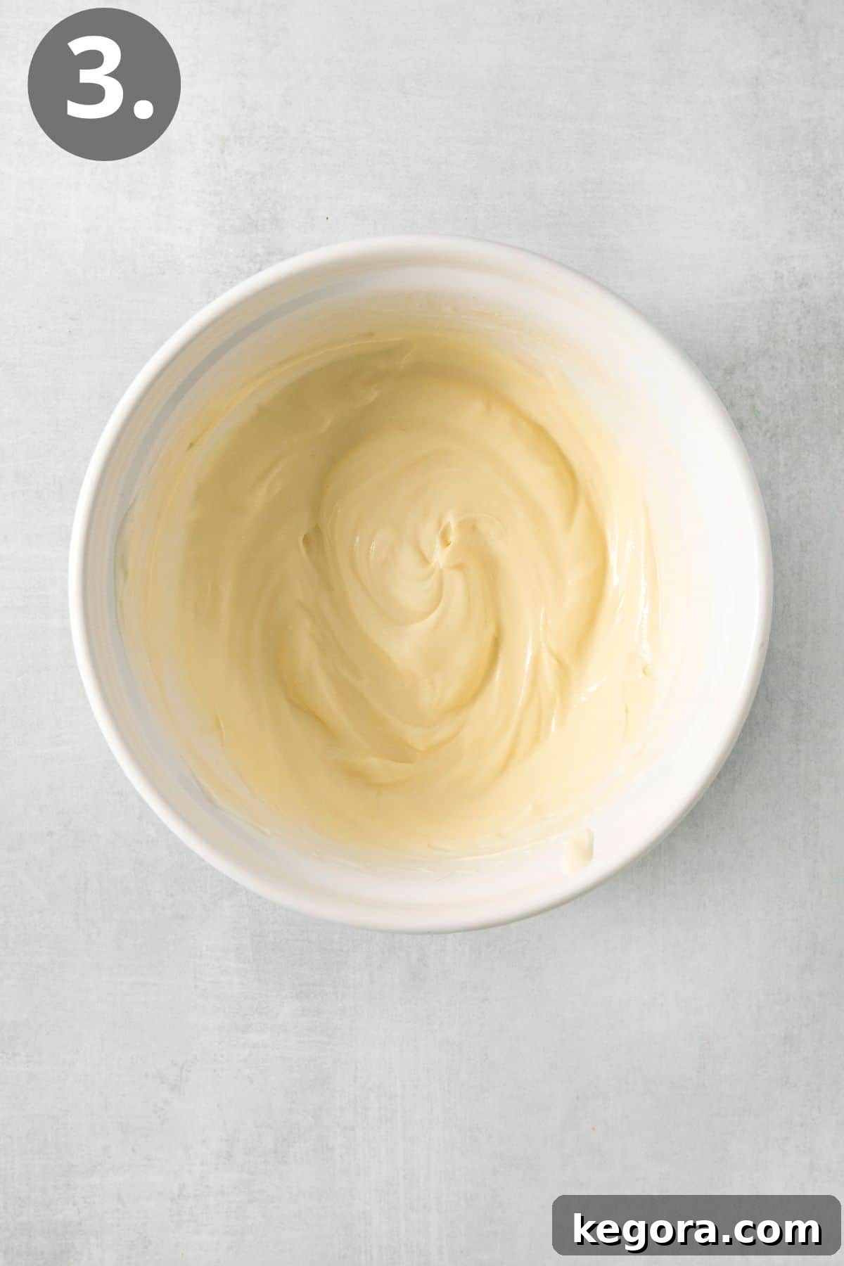 Festive Easter Fruit Delight 7 A creamy white honey mascarpone dressing in a small bowl, with a whisk resting in it.
