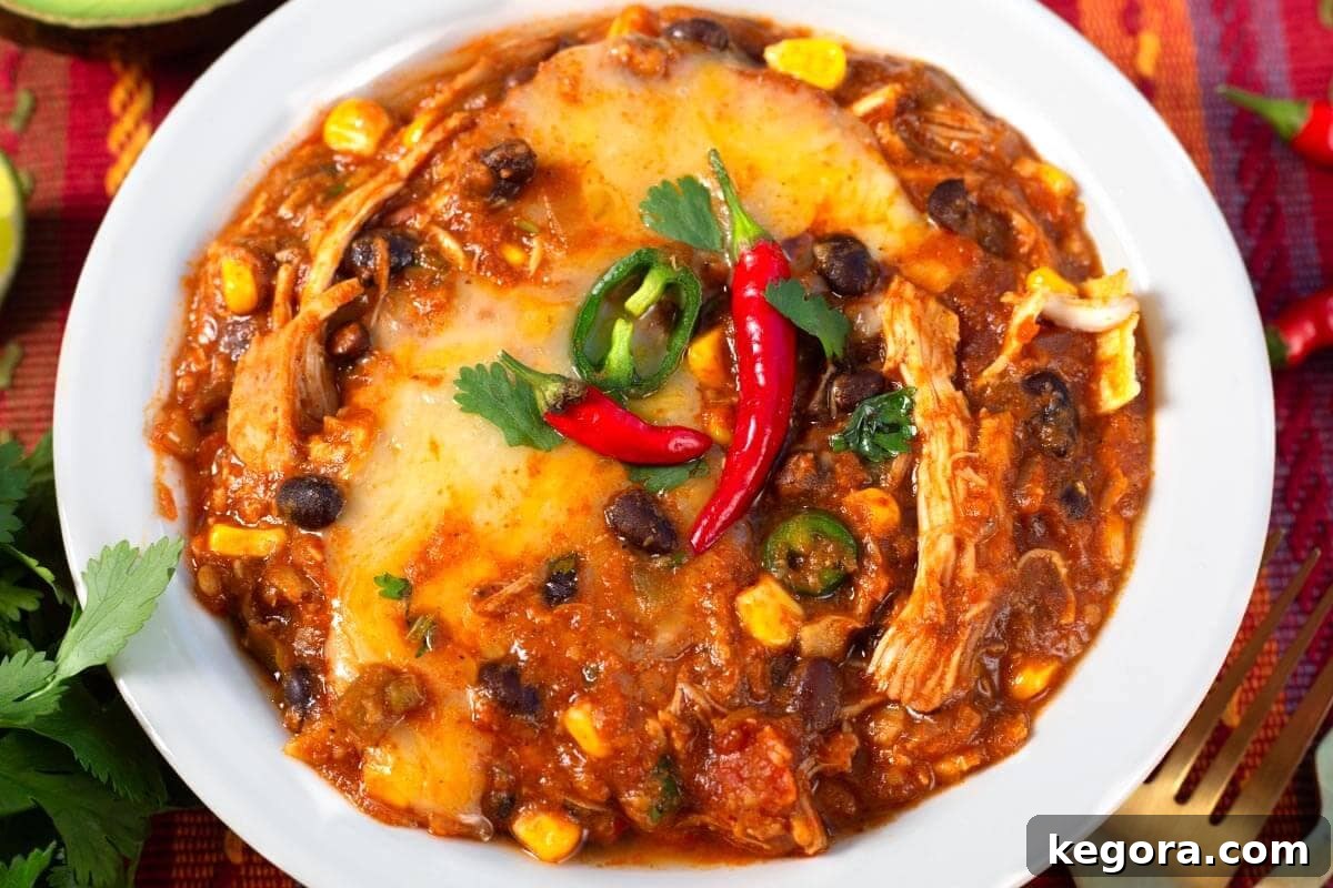 Slow Cooker Cheesy Chicken Enchilada Bake 10 Crockpot Chicken Enchilada Casserole served in a bowl with toppings