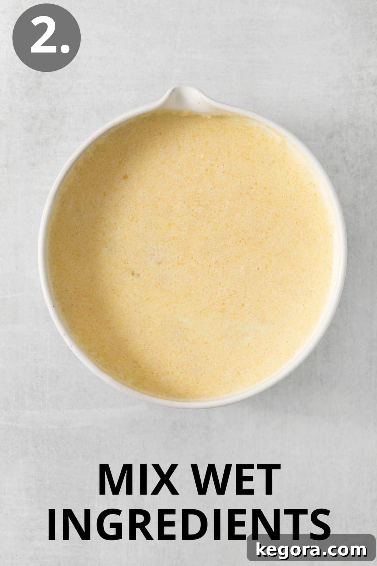 Naturally Sweet Gluten-Free Banana Hotcakes 6 Wet ingredients in a bowl, smoothly whisked and ready to be combined with the mashed banana.