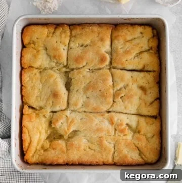 An overhead shot of golden-brown gluten-free biscuits, baked closely together in a rustic baking dish, highlighting their fluffy texture.