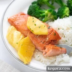 Glazed salmon with pineapple on a bed of rice with broccoli florets.