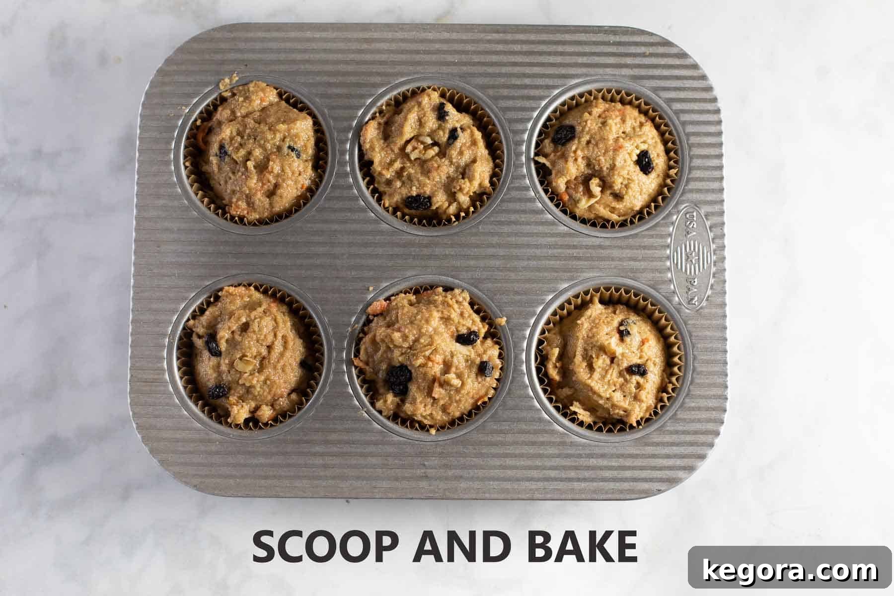 Muffin batter scooped into a lined baking pan, ready for the oven