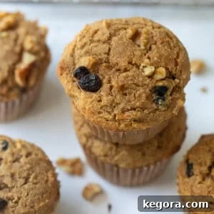 Buckwheat muffins stacked with a wire rack in the background on white marble