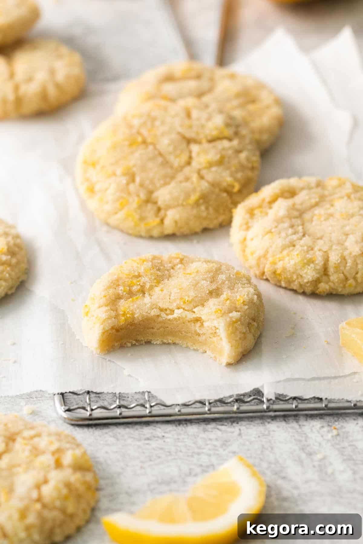Zesty Lemon Gluten-Free Delights 2 Lemon cookies on a cooling rack with a bite taken out of one