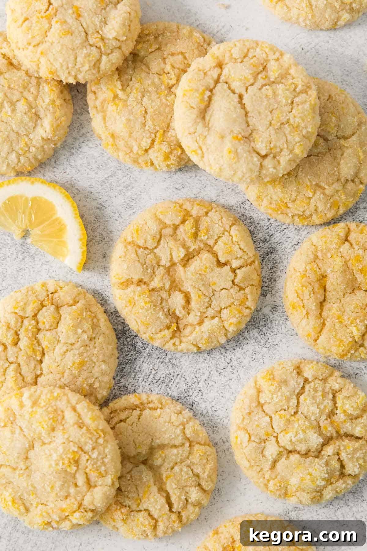 Zesty Lemon Gluten-Free Delights 12 Lemon cookies on parchment paper with a wedge of lemon