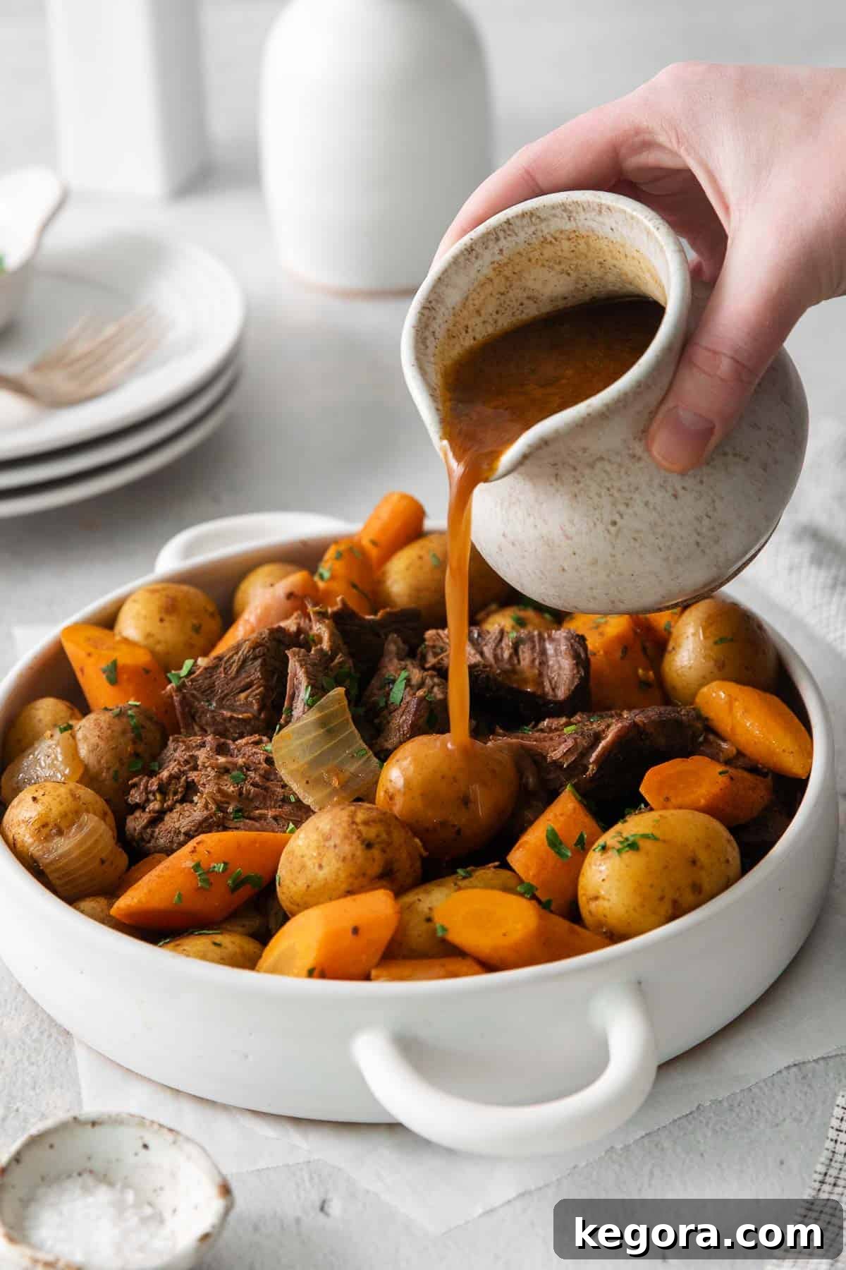 Sirloin roast with carrots and potatoes in a baking dish with rich gravy poured over top