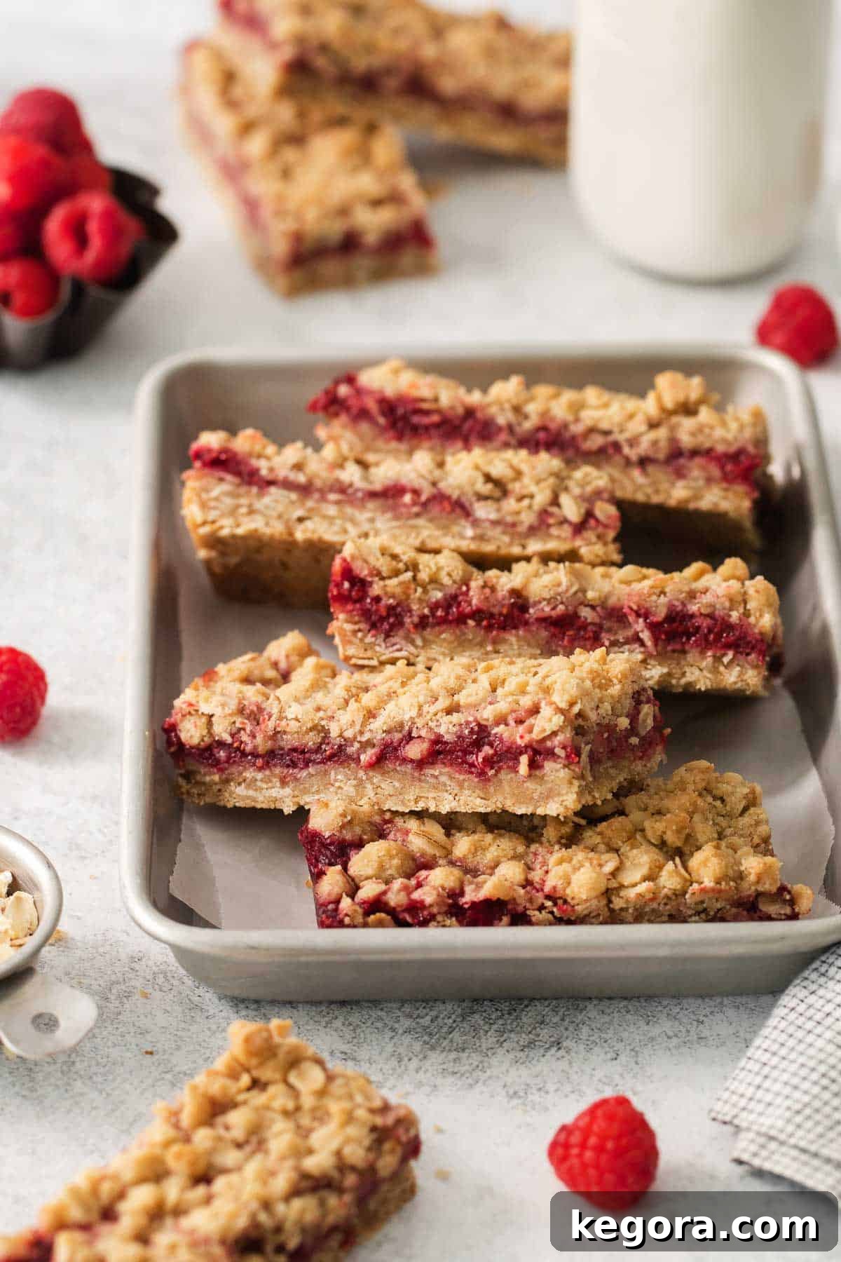 Flourless Raspberry Streusel Squares 2 Gluten-free raspberry bars stacked in a baking dish