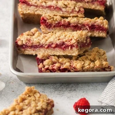 Flourless Raspberry Streusel Squares 5 Gluten-free raspberry bars stacked in a baking dish