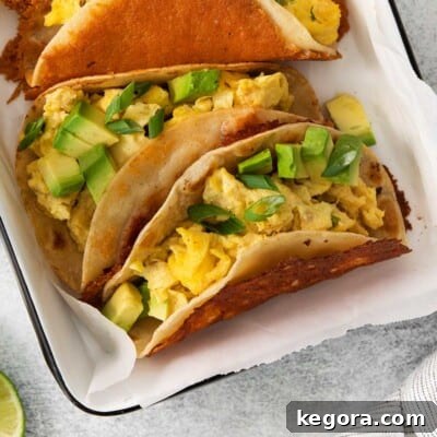 A close-up view of perfectly assembled breakfast tacos, showcasing their crispy cheese shells and fresh toppings, ready to be enjoyed.