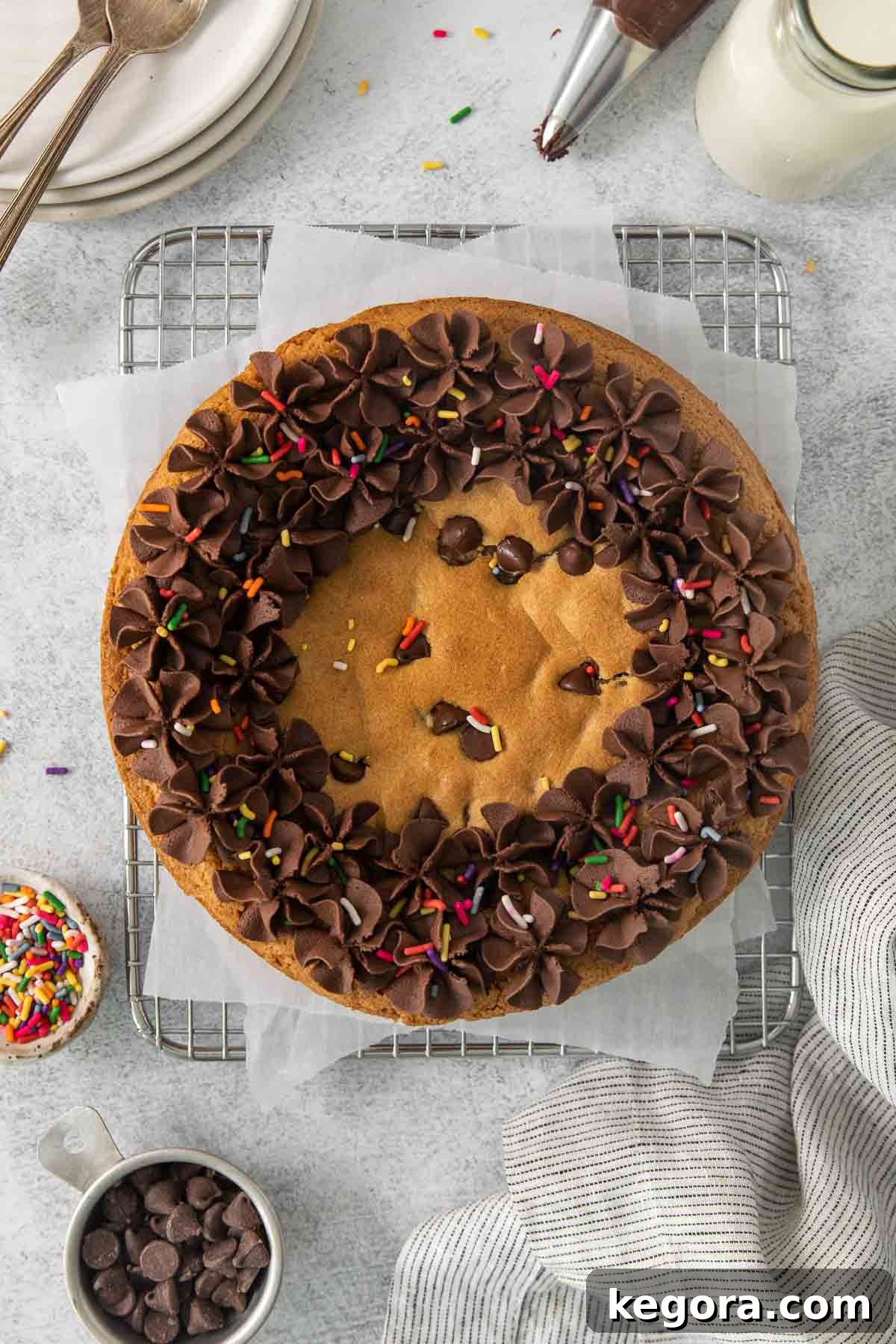 Irresistible Gluten-Free Cookie Cake 2 Overhead shot of a beautifully decorated gluten-free cookie cake on a cooling rack, complete with chocolate frosting and colorful sprinkles, ready for a celebration.