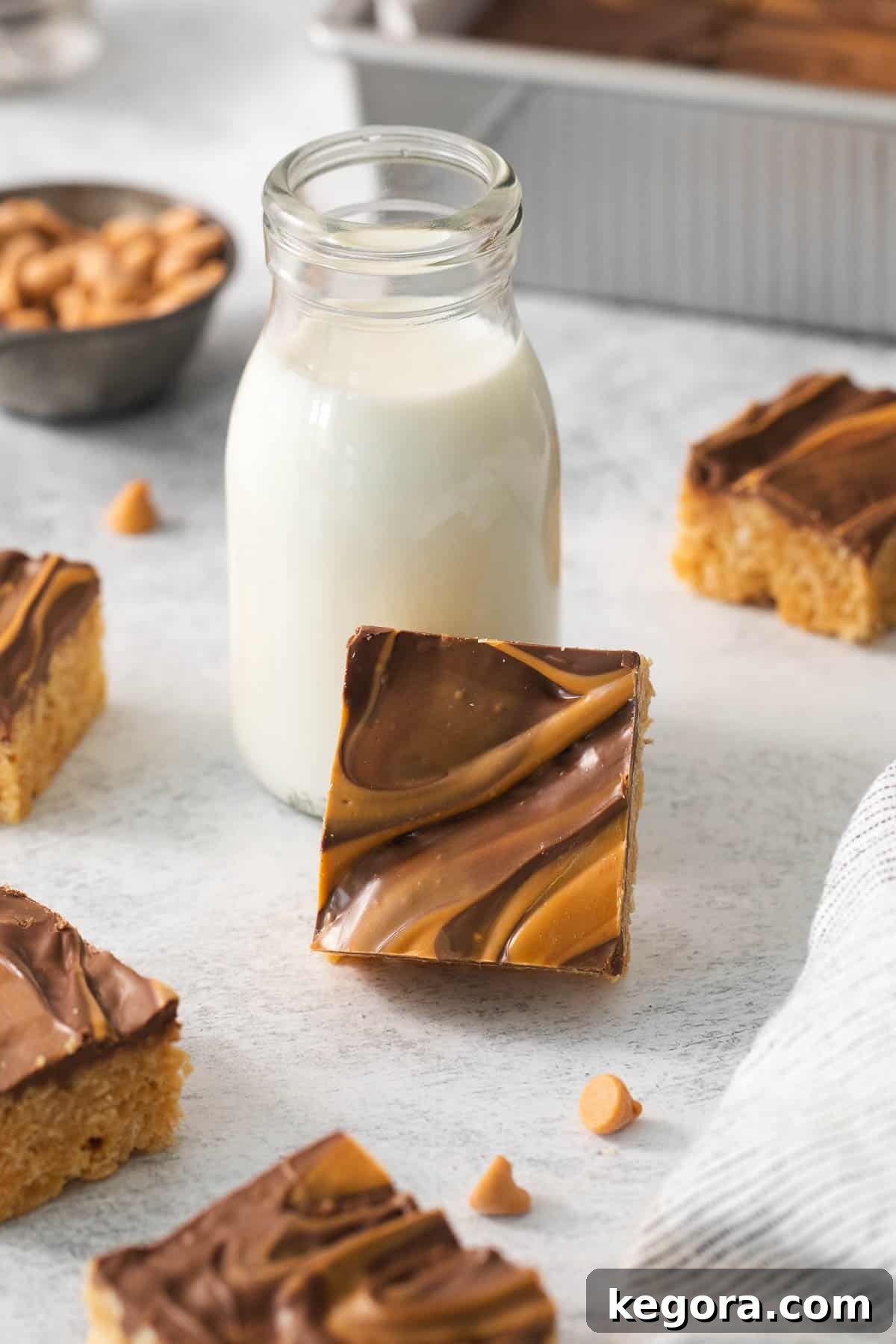 Scotcheroos on a countertop with a glass of milk