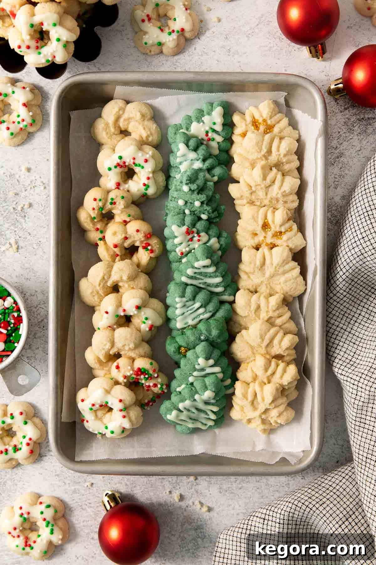 A festive spread of gluten-free spritz cookies artfully arranged on a baking sheet, showcasing various holiday shapes.