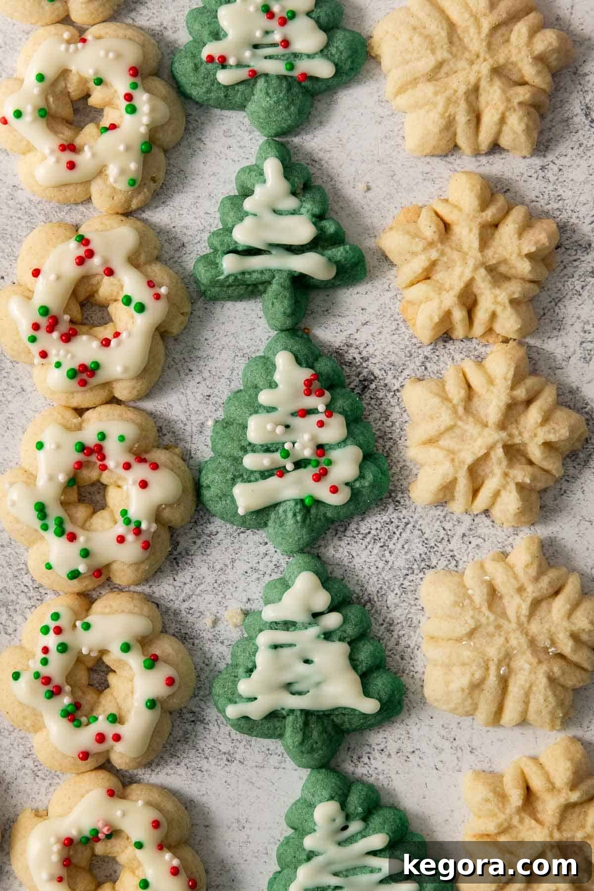 A newly baked batch of gluten-free spritz cookies, beautifully shaped and golden, cooling on a baking sheet.