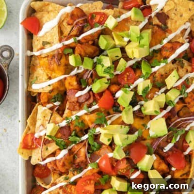 Ultimate BBQ Chicken Nachos 11 BBQ nachos on a sheetpan, showcasing crispy chips, melted cheese, and tender chicken, ready to be served.