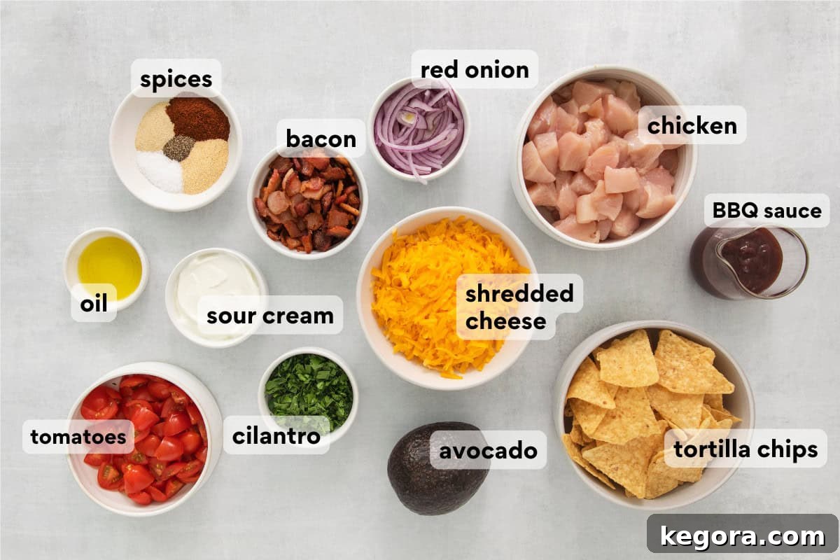 Ultimate BBQ Chicken Nachos 4 A vibrant selection of ingredients for BBQ chicken nachos laid out on a kitchen countertop, including chicken, cheese, chips, and fresh produce.