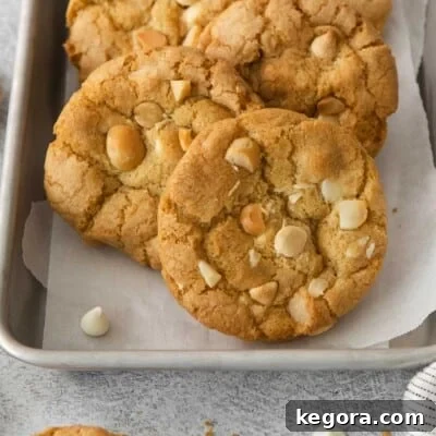 Gluten-free white chocolate macadamia nut cookies on a baking tray with parchment paper