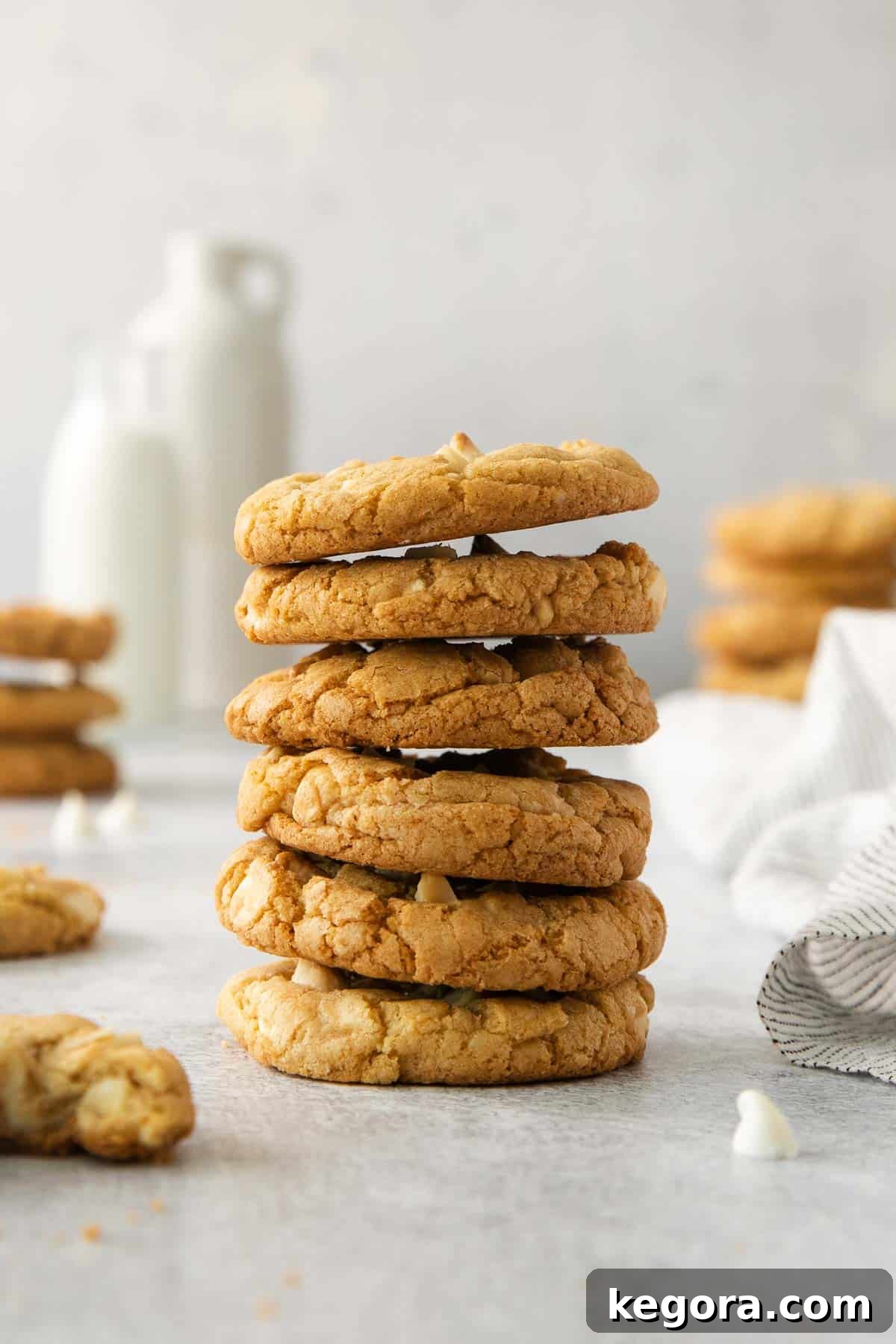 A stack of perfectly baked gluten-free white chocolate macadamia nut cookies on a kitchen counter, ready to be enjoyed.