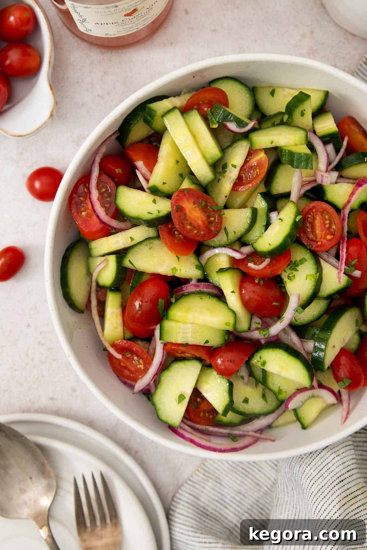 Easy Tangy Cucumber Tomato Salad 3 A vibrant bowl of Marinated Cucumber Tomato Salad, showcasing fresh cucumbers, ripe tomatoes, and thinly sliced red onions, perfectly dressed and ready to serve.