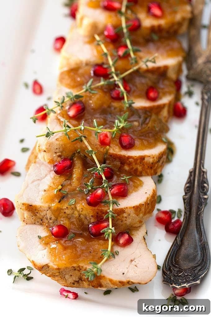 Sliced Balsamic Apple Pork Tenderloin on a white plate with silver fork