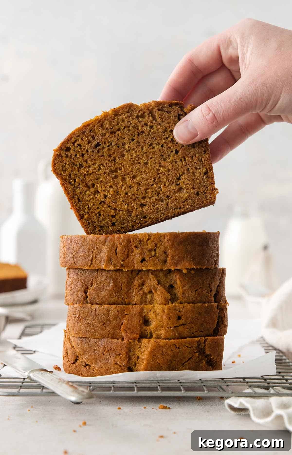 Cozy Gluten-Free Pumpkin Spice Loaf 2 stack of gluten free pumpkin bread with slice being held on top