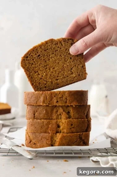 Cozy Gluten-Free Pumpkin Spice Loaf 15 stack of gluten free pumpkin bread with slice being held on top