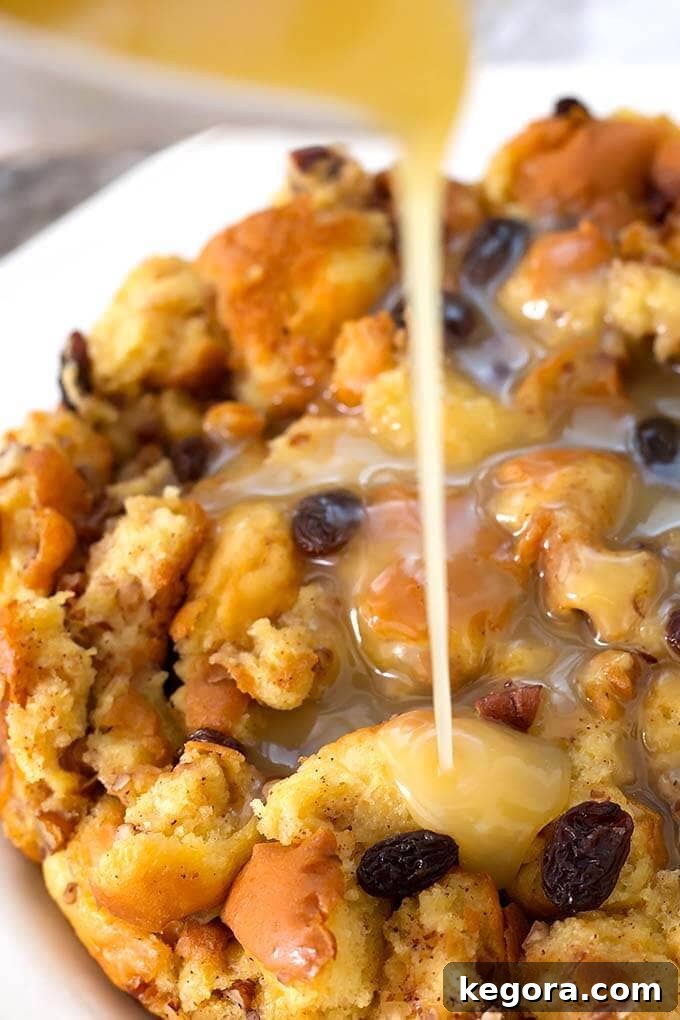 Decadent Instant Pot Bread Pudding 3 Warm Instant Pot Bread Pudding on a plate, with a rich custard being poured over it.