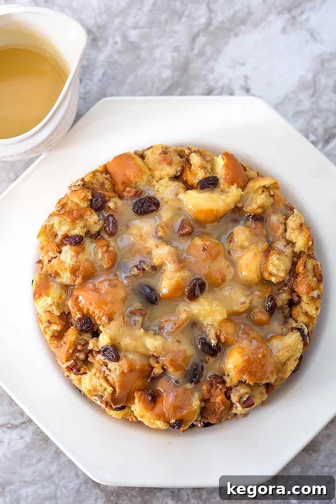 Decadent Instant Pot Bread Pudding 4 Delicious Instant Pot Bread Pudding on a white plate, next to a small cup of rum sauce.