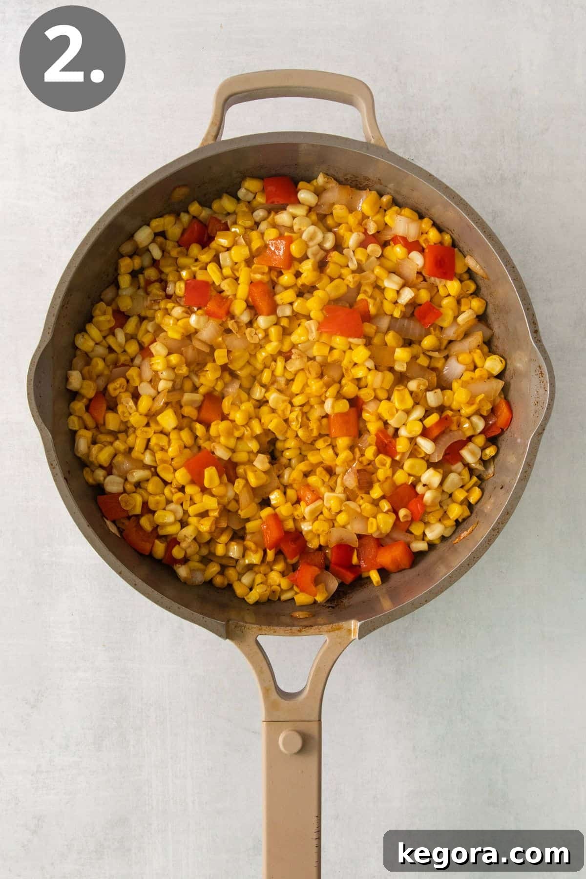 Corn, onion, peppers, and other ingredients cooking in a skillet