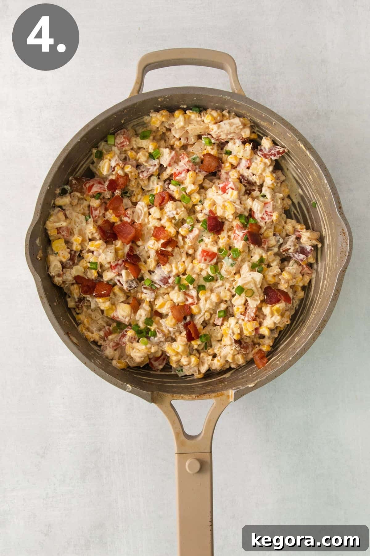 Bacon and green onions added to the cream cheese corn in a skillet