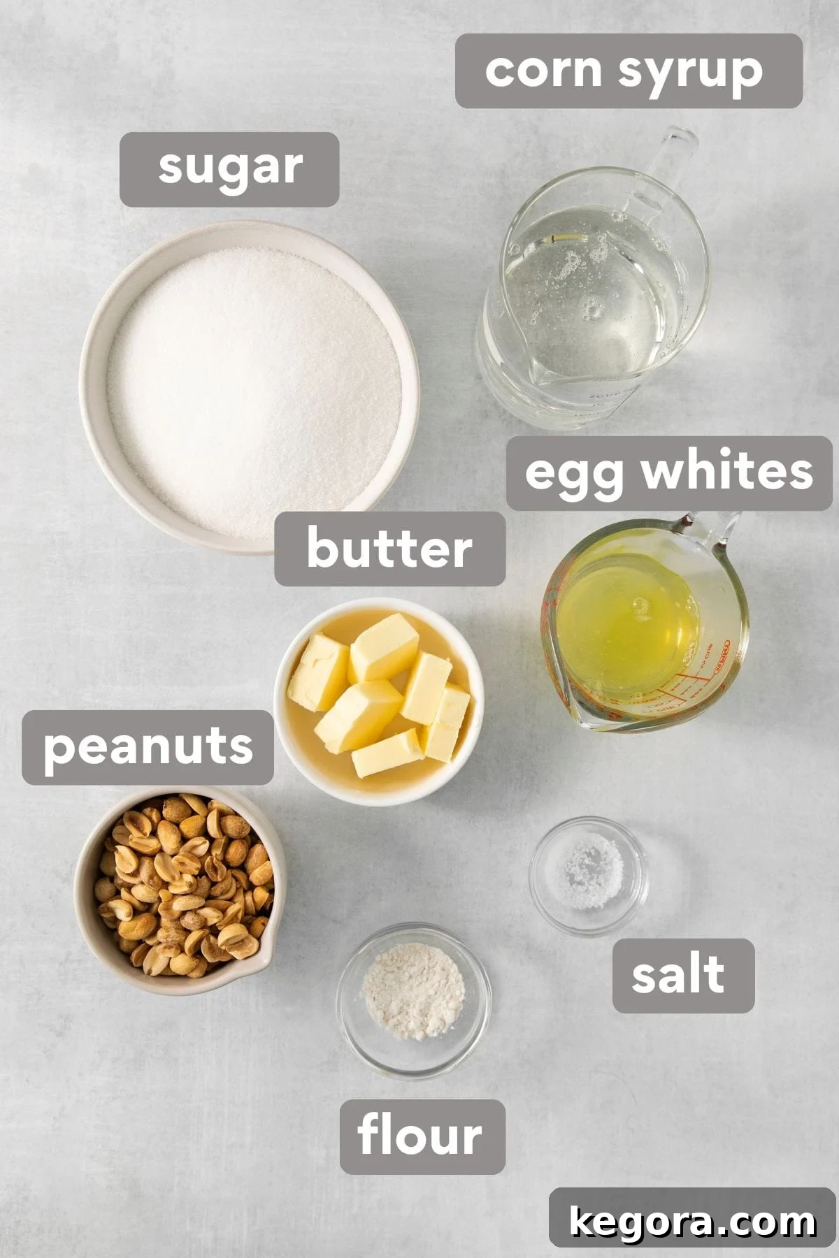 Crafting Irresistible Nougat 4 A collection of nougat recipe ingredients, including sugar, corn syrup, eggs, butter, flour, and peanuts, neatly arranged on a countertop.