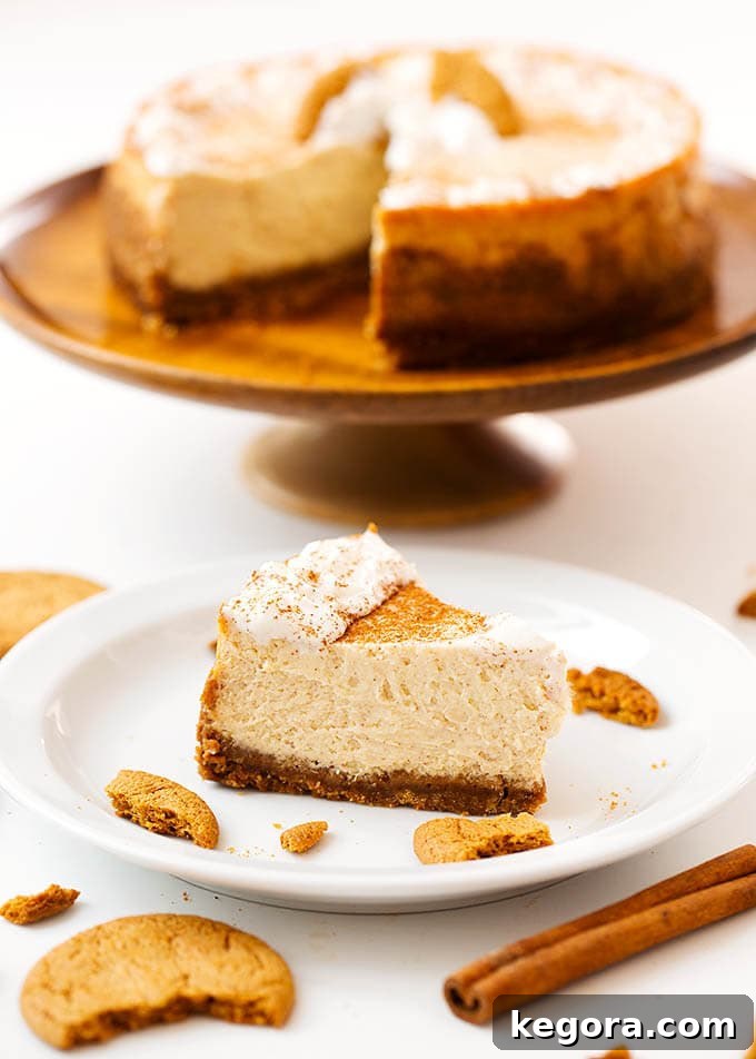 Festive Instant Pot Eggnog Cheesecake 3 Slice of Eggnog Cheesecake on a white plate in front of cheesecake on brown cake stand
