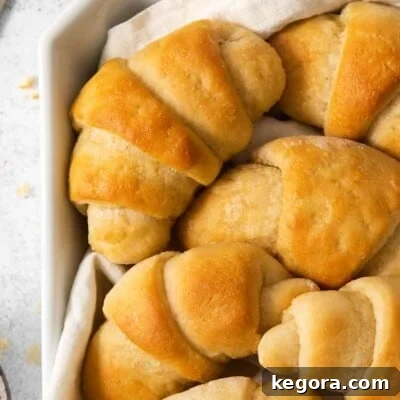 Golden-brown gluten-free crescent rolls nestled in a rustic bowl, with a soft kitchen towel draped nearby.