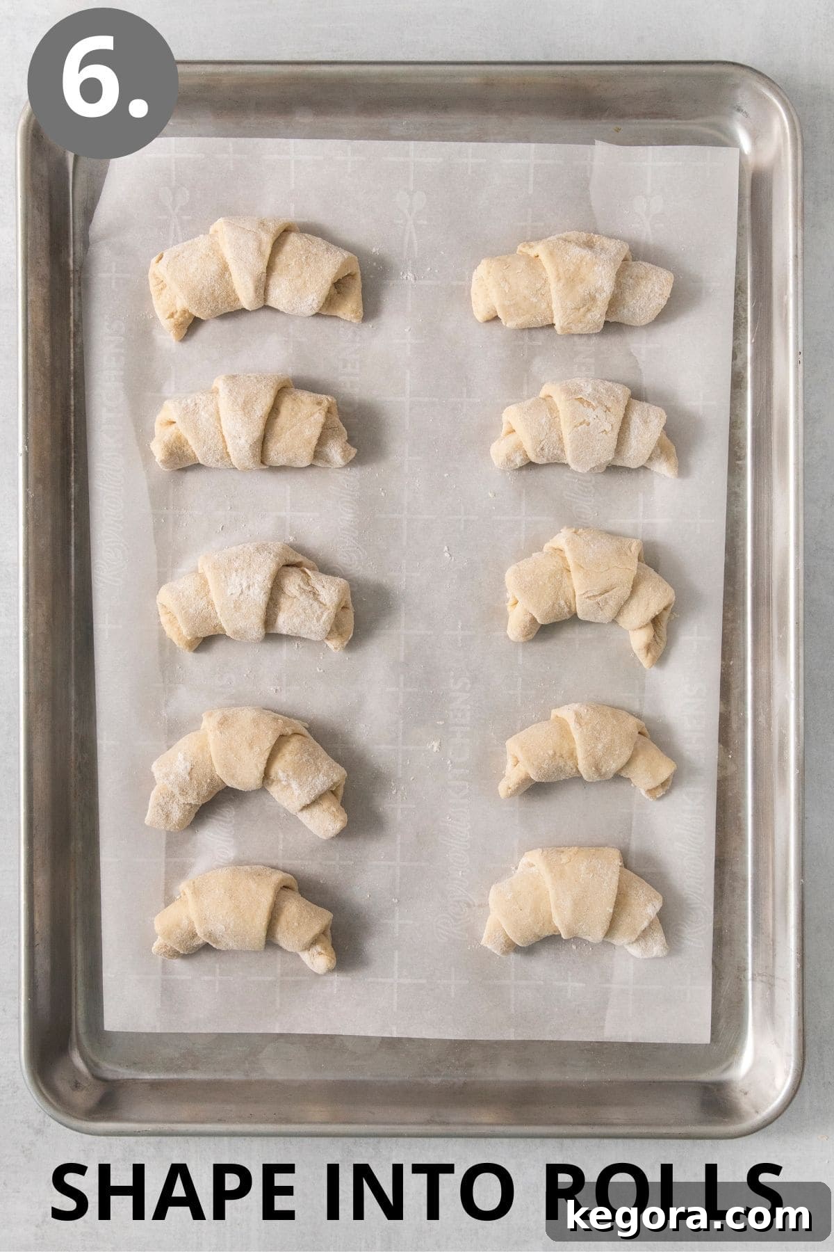 Scrumptious Gluten Free Crescent Rolls 10 Shaped gluten-free crescent rolls, perfectly curved, arranged on a baking sheet, ready for their final rise.