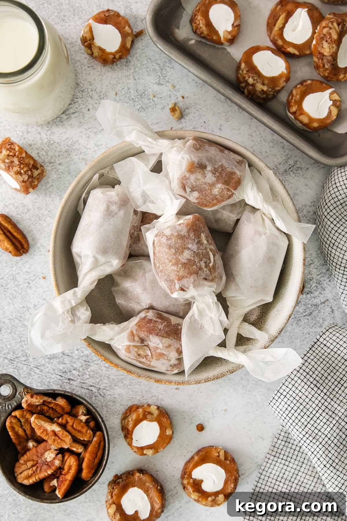 Decadent Pecan Log 10 Pecan roll pieces, wrapped in wax paper, neatly arranged in a bowl.