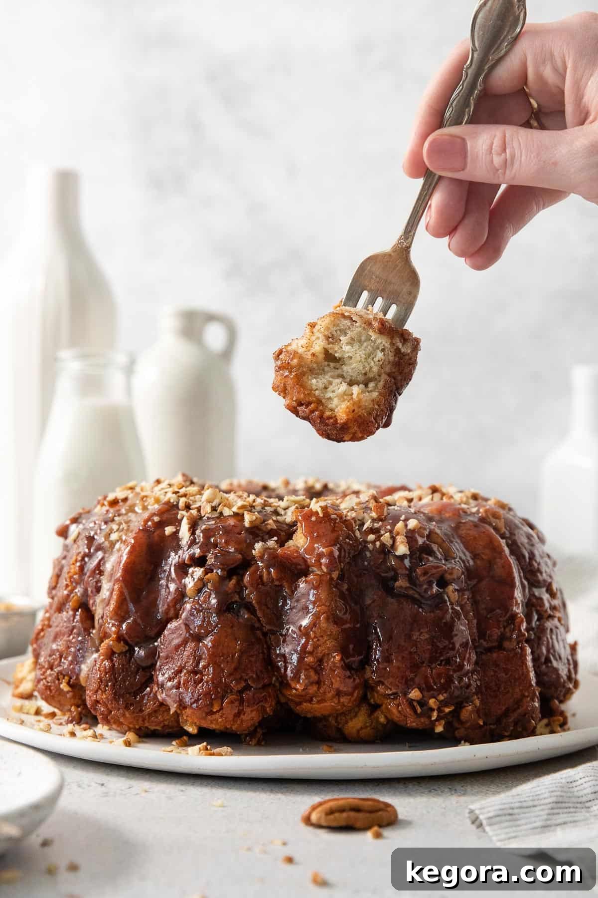 Gooey Gluten-Free Monkey Bread 2 gluten-free monkey bread on a platter with a fork picking up a piece of monkey bread