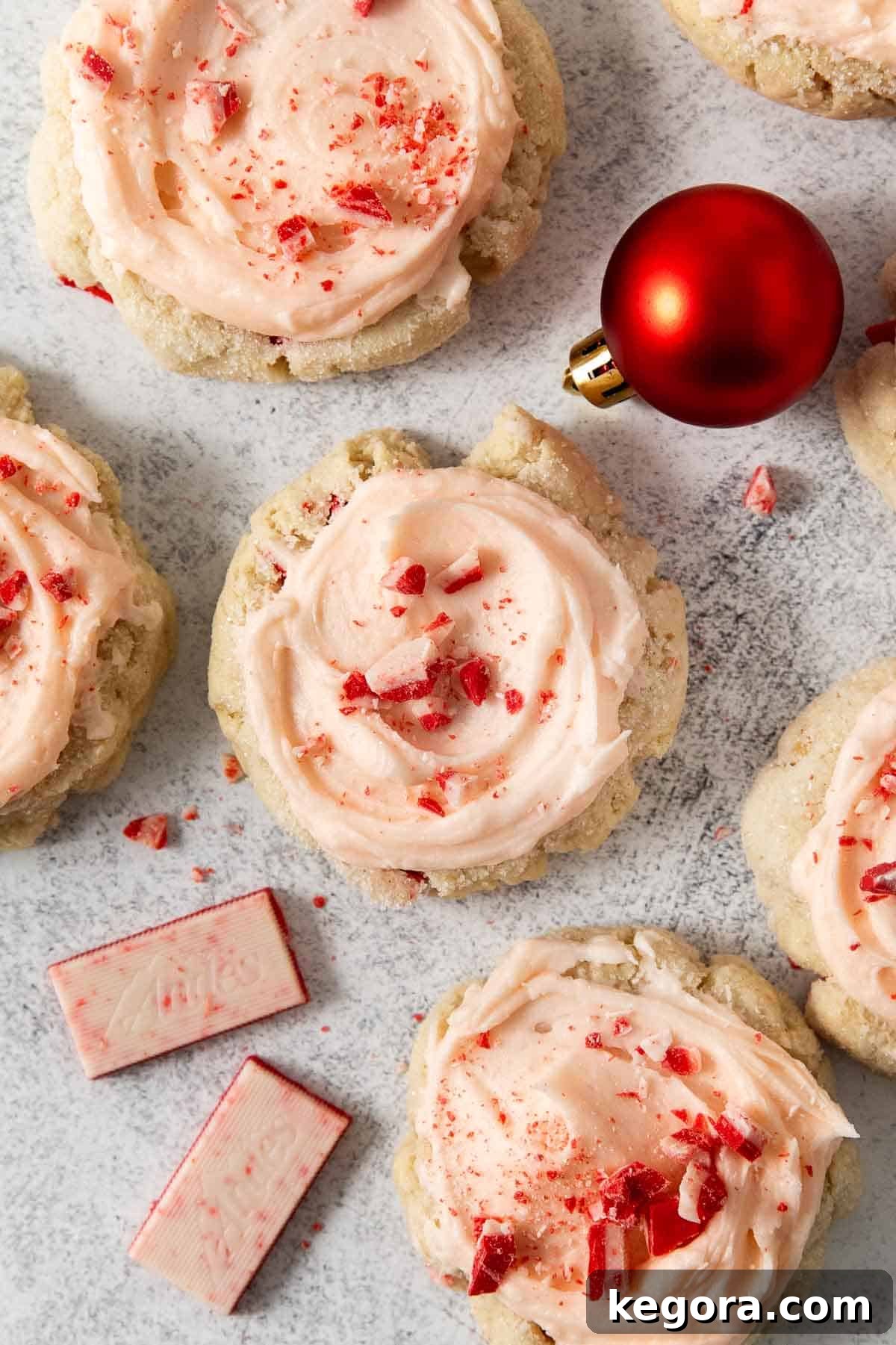 Tender Gluten-Free Peppermint Sugar Cookies with Sour Cream 2 Gluten-free peppermint sour cream sugar cookies arranged on a festive countertop with holiday ornaments and white chocolate peppermint pieces, showcasing their vibrant colors and appealing texture.