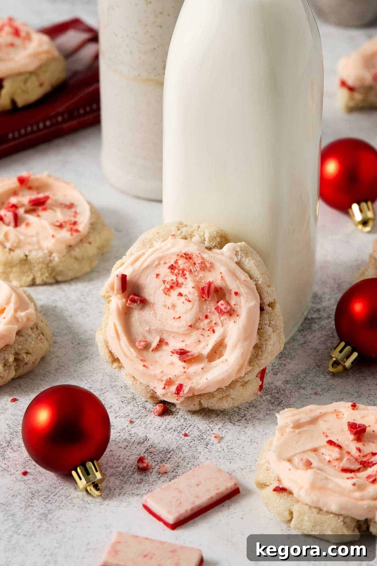 Tender Gluten-Free Peppermint Sugar Cookies with Sour Cream 8 A single perfectly frosted gluten-free peppermint sour cream sugar cookie, leaning against a glass of milk, inviting a cozy holiday moment.