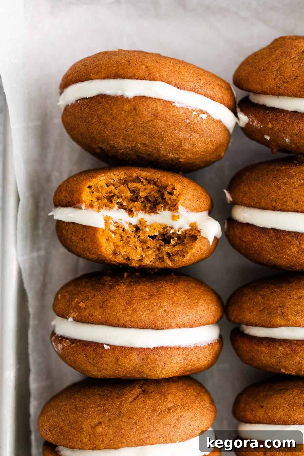 Pumpkin Spice Dreams: Gluten-Free Whoopie Pies 9 A close-up shot of a gluten-free pumpkin whoopie pie with a bite taken out, revealing the creamy frosting and moist cookie texture.