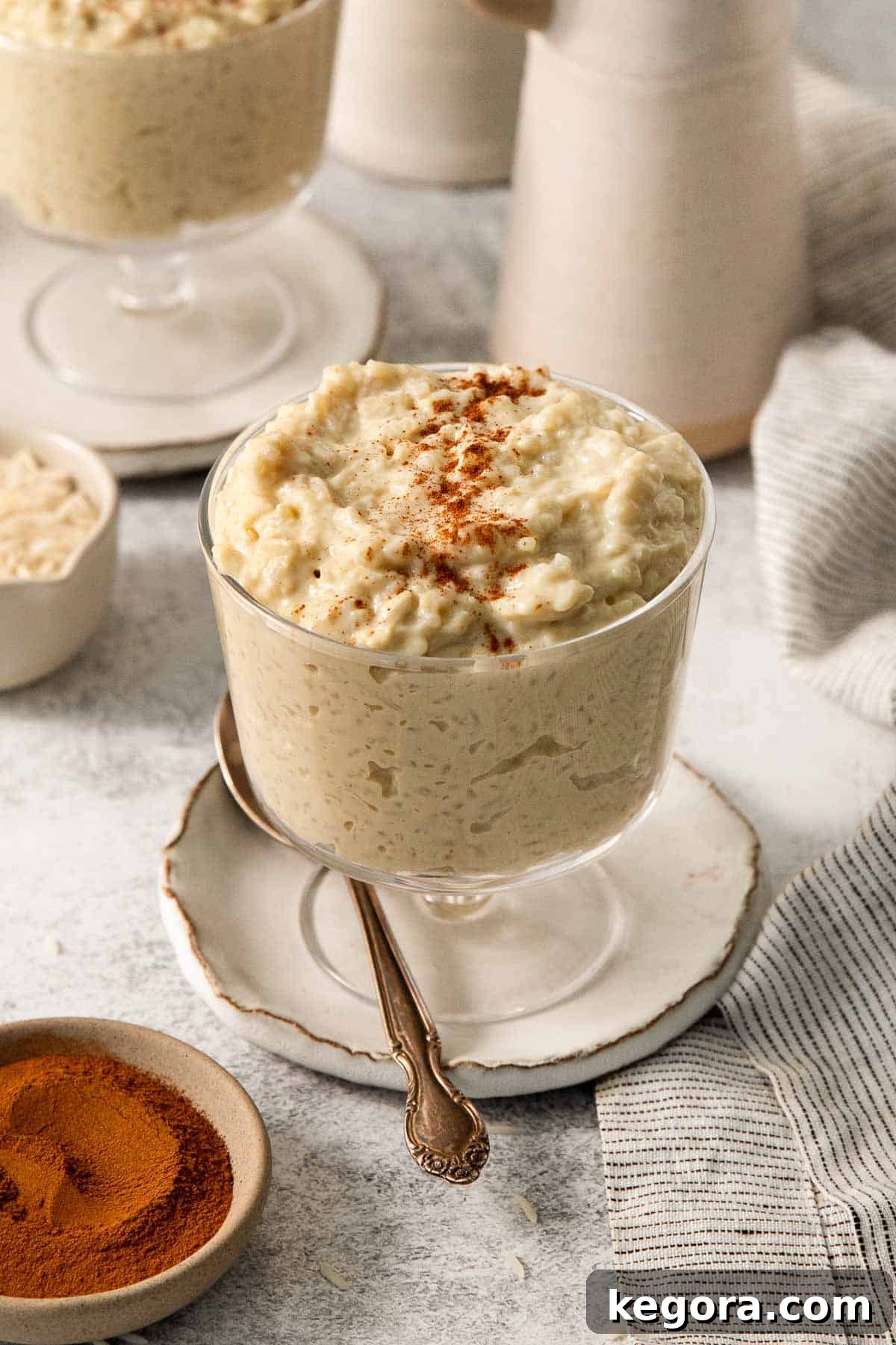 dairy-free rice pudding in a jar with a spoon resting beside it.