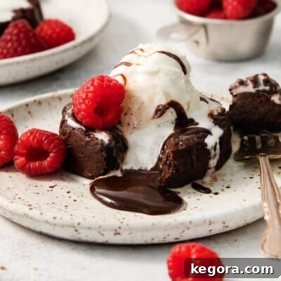 Gluten-free chocolate lava cake on a plate with a fork taking a bite out of it, revealing the molten center.