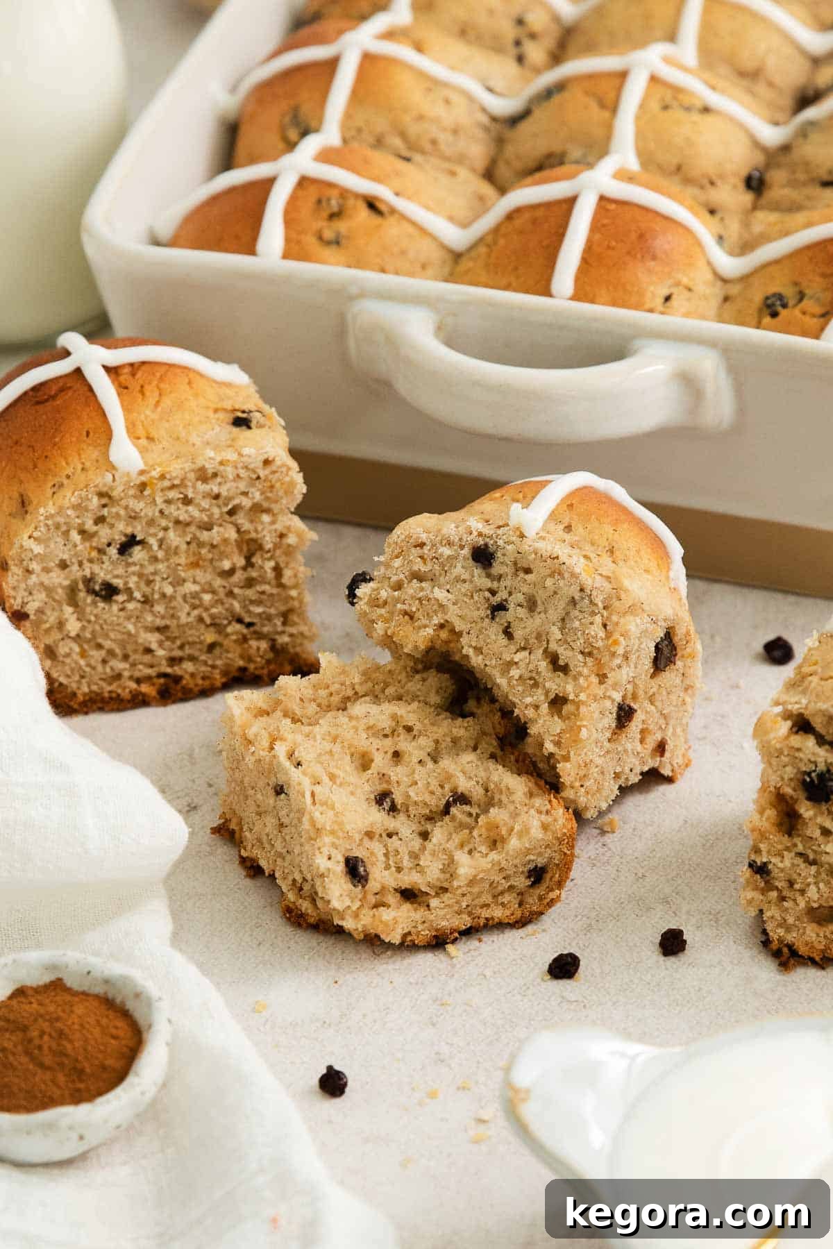 Fluffy Gluten-Free Hot Cross Buns 8 gluten-free hot cross buns sliced in half on a countertop