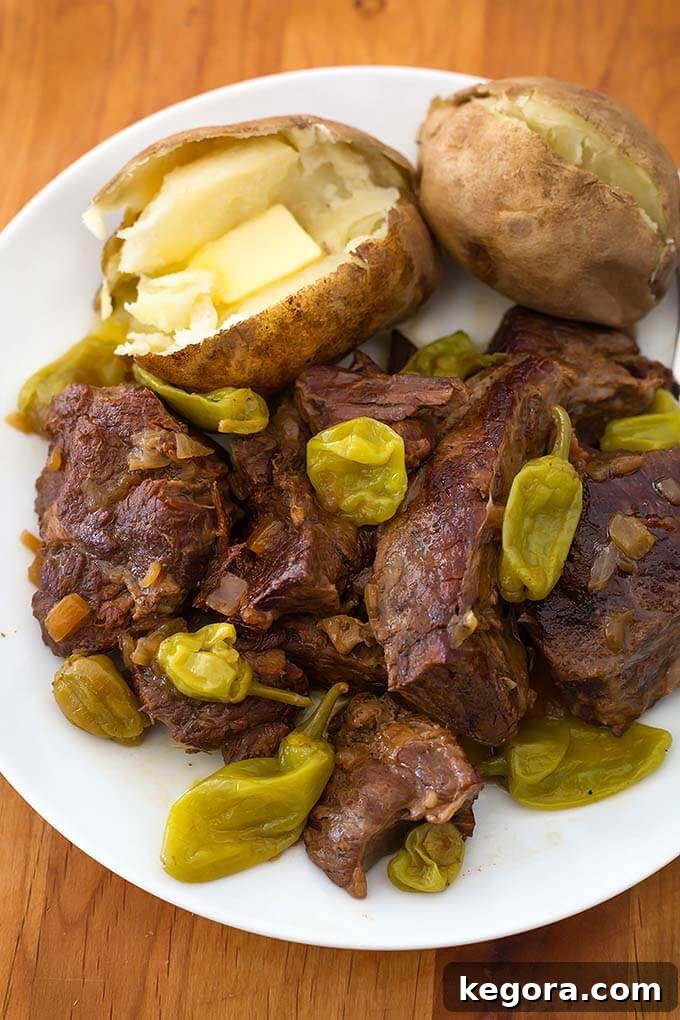 Mississippi Pot Roast with baked potatoes on a white plate