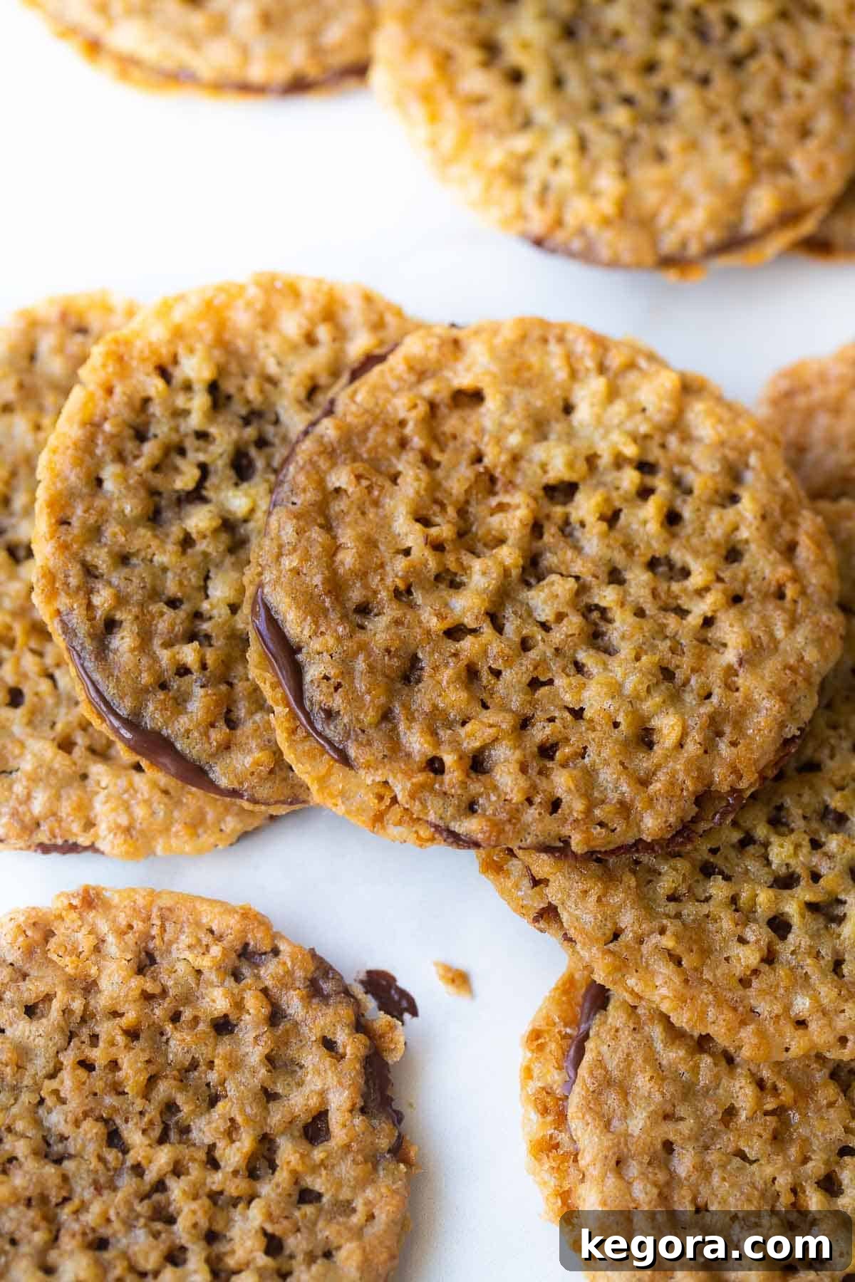 A close-up of perfectly layered lace cookies with dark chocolate filling, showcasing their intricate pattern.